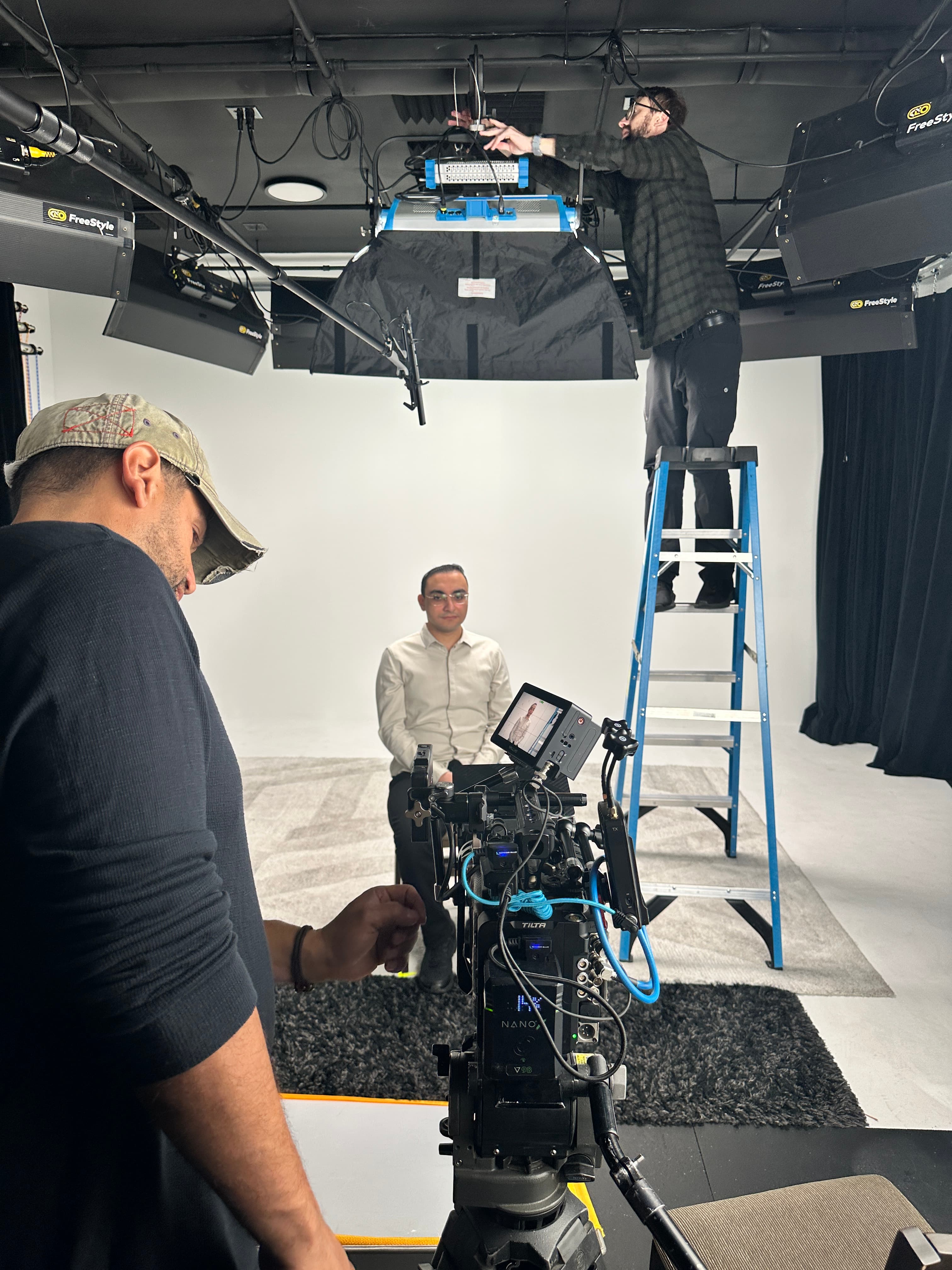 Production crew preparing a camera and studio lighting